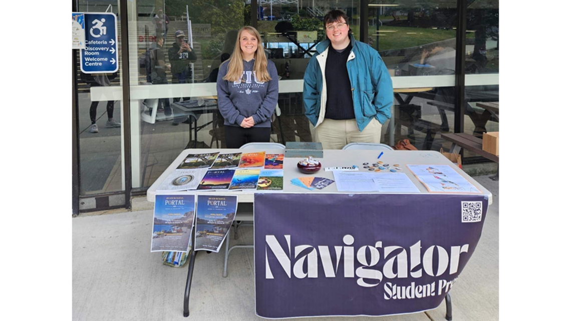 Portal 2023 Masthead selling launch tickets outside the cafeteria with The Nav / Left to right: Portal 2023 Fiction Editor Liz Baltzer, Nav Managing Editor Sean Desrochers